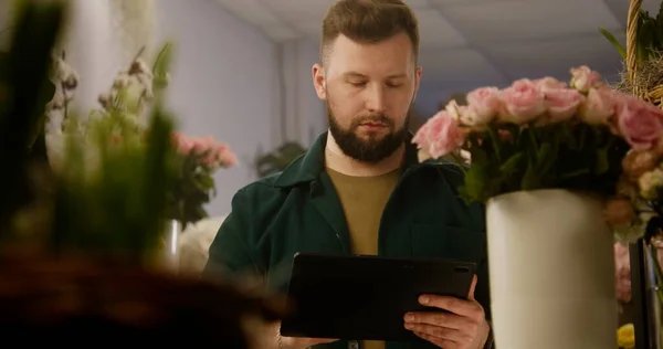 Erkek Çiçekçi Vazodaki Çiçekleri Sayar Dijital Tablet Bilgisayar Kullanarak Müşteri — Stok fotoğraf
