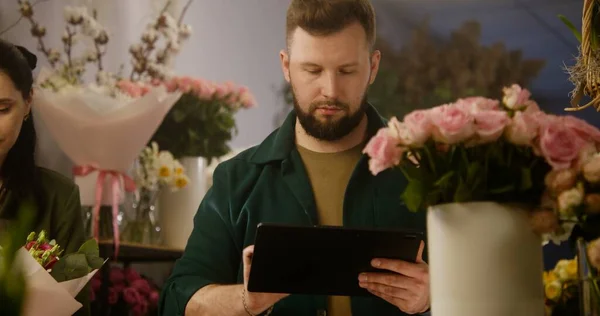 Мужчина Флорист Подсчитывает Цветы Вазе Принимает Заказ Онлайн Помощью Цифрового — стоковое фото