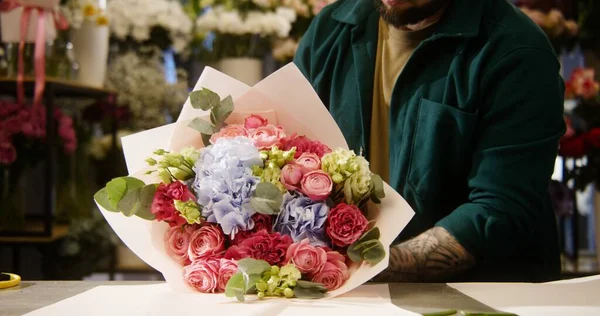 Muž Květinářství Balí Krásné Kytice Používá Balicí Papír Kolega Vázou — Stock fotografie
