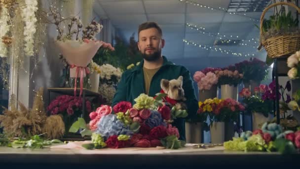 Professionell Manliga Florist Håller Söt Hund Händerna Ler Och Tittar — Stockvideo