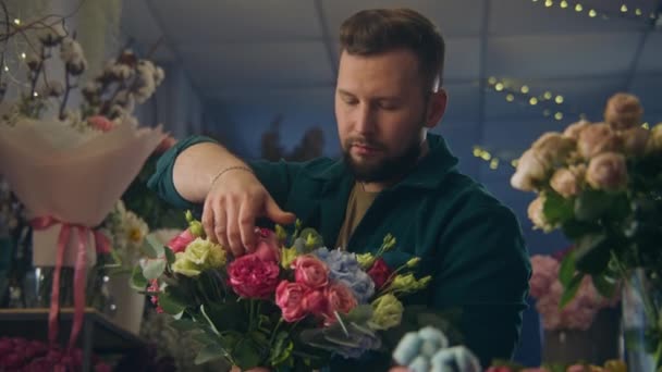 プロの花屋が収集し 手で美しい花束を維持し 笑顔とカメラを見てください 新鮮な花の花瓶が人の周りに立っています 小売業の花ビジネスと起業家精神 肖像画 — ストック動画