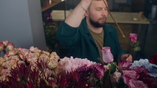 男性のプロの花屋 売り手は花瓶から新鮮な美しい花を取り 花の店で顧客のための花束を収集します 花の概念 花の小売業と起業家精神 — ストック動画