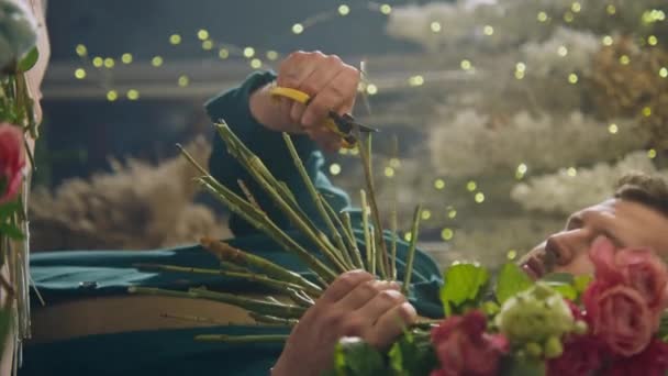男性专业花商 卖家在花店割下鲜花茎 为顾客采摘花束 花卉零售 小企业和创业的概念 垂直录像 — 图库视频影像