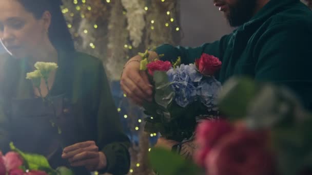 专业花店创业者在花店中加入鲜花的特写 女人帮助同事收集漂亮的花束 花卉企业和创业的概念 — 图库视频影像