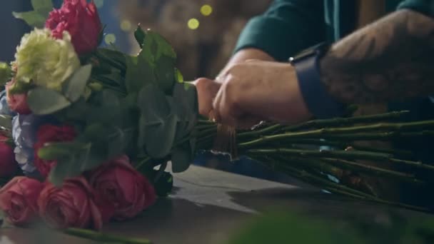 Kwiaciarnia Wiąże Kilka Leżących Stole Kwiatów Używając Sznurka Tnie Sekatorem — Wideo stockowe