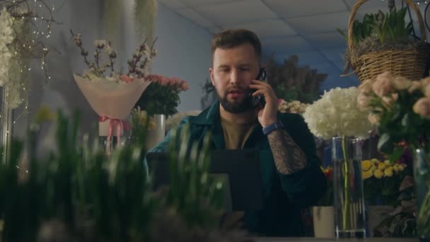 Erkek Girişimci Çiçekçi Müşteriyle Telefonda Konuşuyor Dijital Tablet Kullanarak Internetten — Stok video