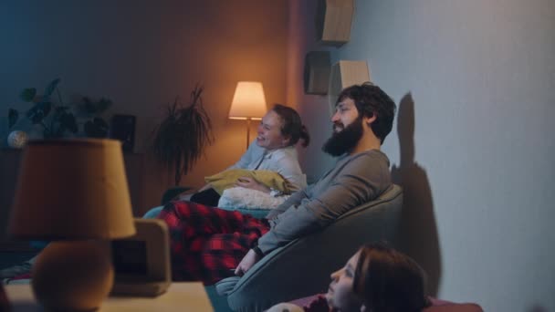 幸せな家族は夜遅くに映画を見る 不眠症の老人は 騒々しい隣人に苛立ち 壁をノックし 休息しようとします 遮音なしのアパート 近隣の概念 — ストック動画