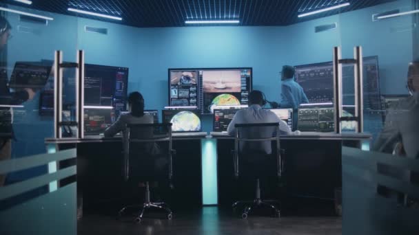 ミッションコントロールセンターの大きなデジタルスクリーンで チームは成功した宇宙ロケットの打ち上げを見ています コンピュータの前の多様な飛行制御労働者は乗組員の任務を監視する 科学宇宙探査 — ストック動画
