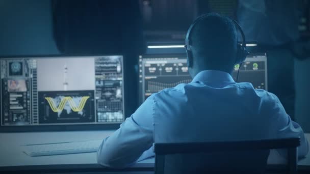 Афроамериканский Сотрудник Управления Полетами Сидит Перед Компьютерами Наблюдает Космической Миссией — стоковое видео