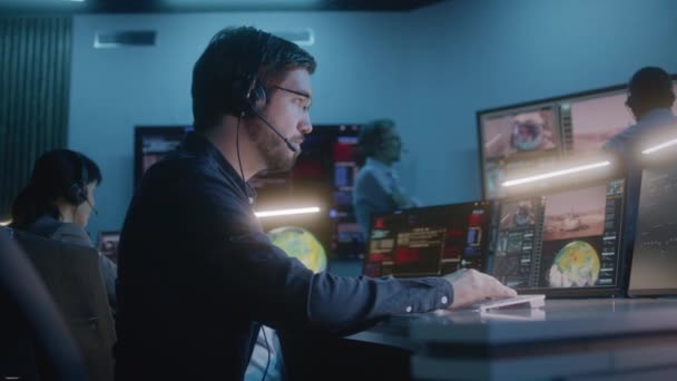 Υπάλληλος Ελέγχου Πτήσης Ακουστικά Κάθεται Μπροστά Από Υπολογιστές Στο Κέντρο — Αρχείο Βίντεο