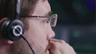 Finans analisti, borsacı bürosunda çalışan kulaklıklı bir tüccar. İşadamı bilgisayar ekranına bakıyor, gerçek zamanlı hisse senetlerini izliyor, borsa grafiklerini değiştiriyor. Kripto para ticareti.