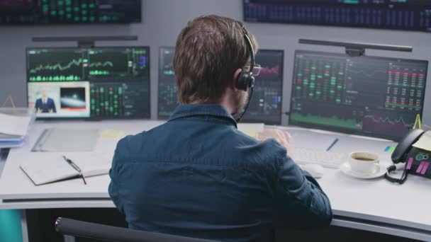Mężczyzna Handlowiec Słuchawki Ogląda Wiadomości Pracuje Biurze Multi Monitor Akcji — Wideo stockowe