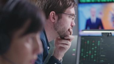 Borsa simsarları borsada gerçek zamanlı hisse senetleri ve borsa çizelgeleri ile komisyoncu bürosunda çalışır. Televizyon haber yayınlı büyük dijital ekran. Kripto para ticareti ve analitik. Yakın çekim..