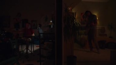 Adam yanıp sönen ışıklarla yatak odasında elektro gitar çalıyor. Komşuda yaşayan genç bir oğlan ve kız, geceleri davul seti ve ukulele çalarlar. Duvarla ayrılmış iki odanın görüntüsü. Mahalle kavramı.