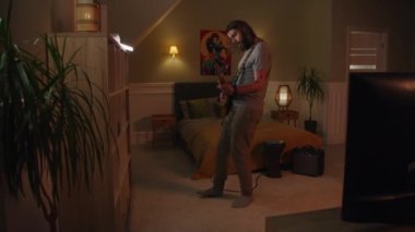 Adam geceleri yatak odasında elektro gitar çalıyor. Kamera görüş açısını değiştiriyor. Yan evde oturan genç kız ve erkek, davul ve ukulele çalıyor. Duvarla ayrılmış iki oda ya da daire. Komşuluk kavramı.