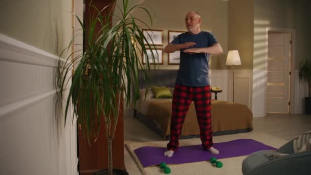 Elderly Man Smiles Does Physical Exercises Bedroom Camera Changes View — Stock Video