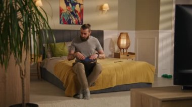 Konsantre yetişkin adam geleneksel djembe davul çalıyor. Kamera, komşu çocuğun evde davul setiyle müzisyen becerisi uygulamasına bakıyor. Daireler duvarla ayrılmış. Mahalle. Kırbaç tavası.