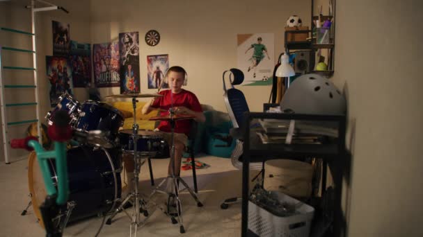 Młody Chłopiec Słuchawkach Ćwiczy Umiejętności Muzyczne Pomocą Zestawu Perkusyjnego Domu — Wideo stockowe