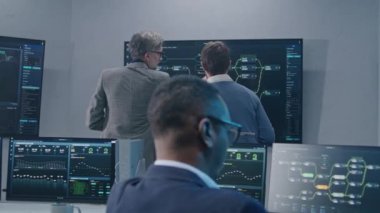 Bilgi işlem uzmanları ve yazılım mühendislerinden oluşan çok ırklı bir ekip veri sunucusu, canlı analiz çizelgeleri ve bilgisayarlardaki engelleme ağı ve izleme odasındaki büyük dijital ekranlar üzerinde çalışıyor..