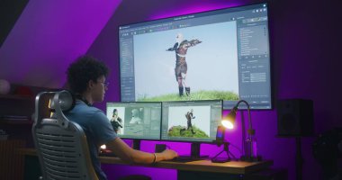 Genç yaratıcı 3D tasarımcı video oyunu karakteri ya da animasyonu yaratıyor, ev ofisinde uzaktan çalışıyor. 3B modelleme ve tasarım için profesyonel yazılım arayüzüne sahip bilgisayar ve büyük dijital ekran.