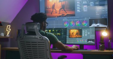 Afrikalı Amerikalı editör renk düzeltmesi yapıyor, aksiyon filmi düzenliyor, evde çalışıyor. Bilgisayar ve büyük dijital ekranda RGB araçları ve tekerlekleriyle yazılım arayüzü. Film sonrası prodüksiyon kavramı.