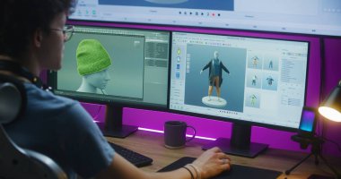 Genç 3D tasarımcı video oyunu karakteri veya giysileri oluşturur, evden bilgisayarla ve büyük dijital ekranla uzaktan çalışır, profesyonel yazılım arayüzü ve 3D modelleme ve tasarım araçları ile.