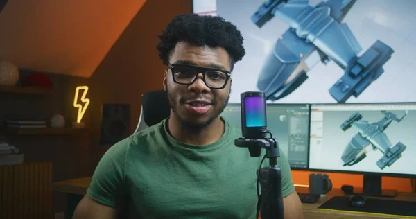 非裔美国人3D设计师在镜头前使用麦克风 录音视频教程讲述3D建模和动画 计算机和大数字屏幕上的3D飞机设计和软件接口 — 图库照片
