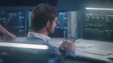 Telefon kullanarak profesyonel bilişim teknolojisi uzmanı sohbetleri, büyük veri sunucusu, engelleme ağı ve canlı analiz çizelgeleri olan bilgisayarın önünde oturmalar, izleme ofisinde çalışmalar. Siber güvenlik kavramı.