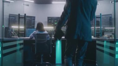 Yazılım programcıları bilgisayarlar üzerinde çalışır. IT teknik uzmanı modern izleme odasına giriyor, veri sunucusu, gerçek zamanlı analiz grafikleri ve büyük dijital ekranlar üzerindeki engelleme ağı ile çalışıyor.