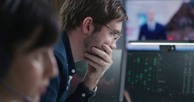 Borsa simsarları borsada gerçek zamanlı hisse senetleri ve borsa çizelgeleri ile komisyoncu bürosunda çalışır. Televizyon haber yayınlı büyük dijital ekran. Kripto para ticareti ve analitik. Yakın çekim..