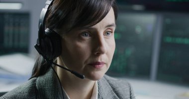 Komisyoncu bürosunda ya da bankada çalışan kulaklıklı kadın borsa simsarının yüzü. İş kadını bilgisayar ekranına bakıyor, borsa grafiklerini izliyor. Yatırım ve kripto para ticareti.