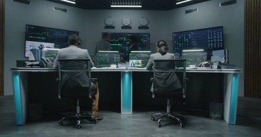 Çoklu etnik gruptan tüccarlar, gerçek zamanlı sergilenen çoklu monitörlü bilgisayarlar üzerinde çalışıyorlar. Meslektaşlar büyük ekranlarda döviz piyasalarının grafiklerini analiz ederler. Kripto para ticareti ve yatırım. Uzaklaştır.