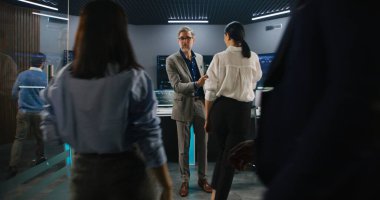 İş elbisesi giymiş olgun bir yönetici izleme odasında programcıları karşılar ve kameraya bakar. Büyük veri mühendisleri çalışmaya başlar. Gerçek zamanlı analiz çizelgeleri olan birden fazla büyük ekran. Dolly vurdu..