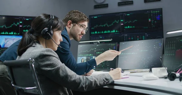 女股票交易员和投资顾问在计算机上讨论实时股票数据 同事们在经纪公司工作 有交易市场图表的大数字显示屏 投资和分析 — 图库照片