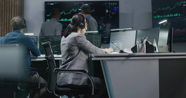 不同的金融分析师对计算机上的实时股票进行监控 一个由商人组成的小组在银行工作 显示交易市场图表的大数字显示屏 加密货币交易和分析 — 图库照片