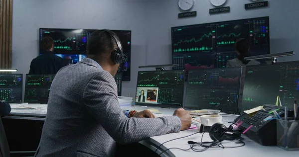 手握钢笔的非裔美国商人在电脑上工作 拥有实时股票 同事们在大屏风的背景下分析外汇市场图表 贸易和投资的概念 — 图库照片