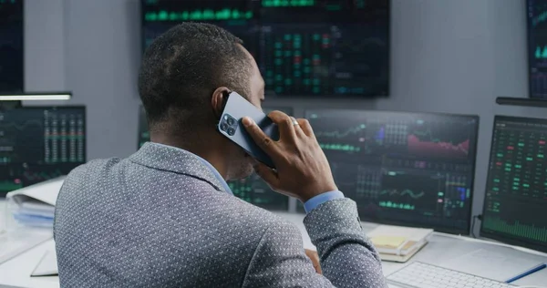 Afroamerykanin Rozmawia Przez Telefon Pracuje Biurze Maklerskim Monitory Duży Ekran — Zdjęcie stockowe