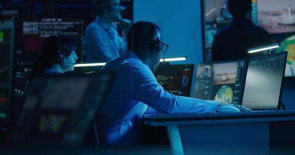 非裔美国人飞行管制员在飞行管制中心的多显示器计算机上监测空间飞行任务 团队在大屏幕上观看成功的宇宙飞船升空 空间探索 — 图库照片