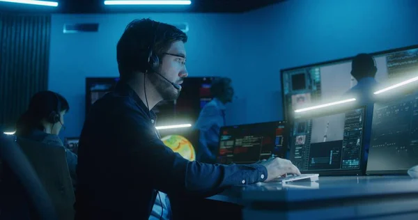 飞行控制操作员坐在飞行控制中心的计算机前 监测空间飞行任务 一组工作人员在航天器升空后拍手在大的数字屏幕上展示 — 图库照片