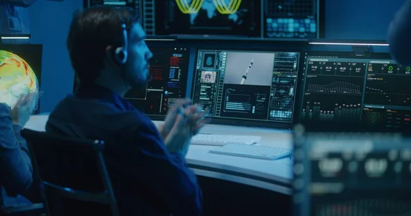 Różnorodni Operatorzy Kontroli Lotów Zestawach Słuchawkowych Monitorują Misję Kosmiczną Komputerach — Zdjęcie stockowe