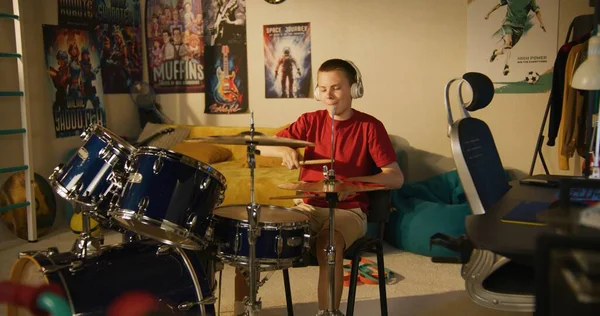 Fiatal Fiú Fülhallgatóban Gyakorolja Zenész Készségek Segítségével Dob Kit Otthon — Stock Fotó