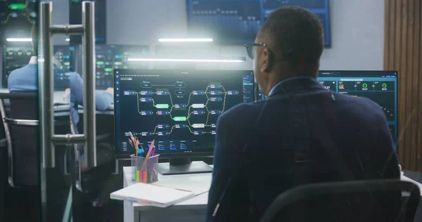 技术支助专家坐在显示区块链网络图和服务器数据的计算机上 大数据科学家在监测室工作 墙上的大屏幕 网络安全的概念 — 图库照片