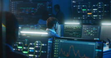 Teknik destek uzmanı klavye tipleri bilgisayar başında blockchain ağ haritası ve sunucu verileri ile oturuyorlar. Büyük veri bilimcileri gece geç saatlerde izleme odasında çalışıyorlar. Siber güvenlik kavramı.