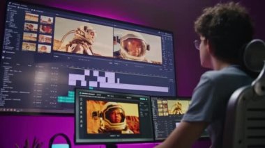Genç editör, video yapımcısı, astronotlarla film düzenliyor, ev ofisinde çalışıyor. Bilgisayar ve büyük dijital ekrandaki araçlar ve ses parçaları ile film görüntüleri ve yazılım arayüzü. Post prodüksiyon kavramı.