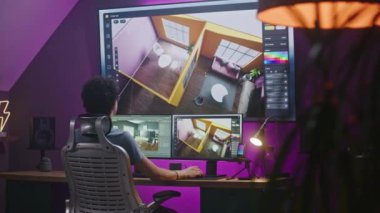 Genç 3D tasarımcı modern ev iç mimarisi yaratıyor, ev ofisinde bilgisayar ve büyük dijital ekranda profesyonel yazılım arayüzü ve 3D modelleme ve planlama araçlarıyla tasarım projesi üzerinde çalışıyor.