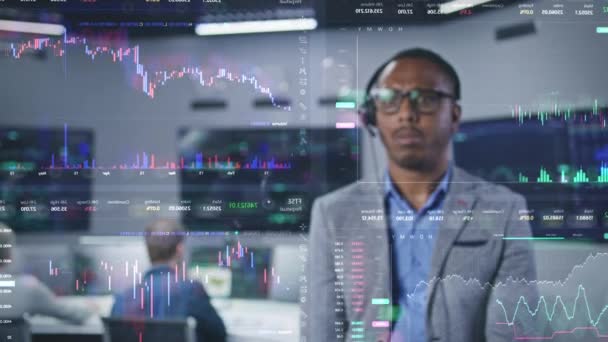 アフリカ系アメリカ人の投資専門家がオフィスのリアルタイム株式を分析します ガラスの壁に暗号通貨チャートの3Dグラフィックス 未来的なVfxアニメーション 従業員はバックグラウンドでコンピュータで作業します — ストック動画