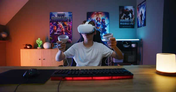 Um gato gamer com fones de ouvido dentro de sua configuração de jogador  joga videogame em um pc gamer