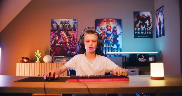 ヘッドフォンのプロの十代のゲーマーは スタイリッシュなネオンルームで夜にコンピュータ上でオンラインビデオゲームをプレイ マイクに話します Esportsトーナメント 自宅でゲーム Pc画面の視点からの眺め — ストック写真