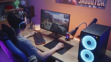 Genç oyuncu, PVP savaş simülatöründe oynarken takım arkadaşlarıyla konuşur ve tankları kontrol eder. Bilgisayar monitörü çevrimiçi video oyunu canlı yayını ya da siber spor turnuvasıyla. Arka plan.