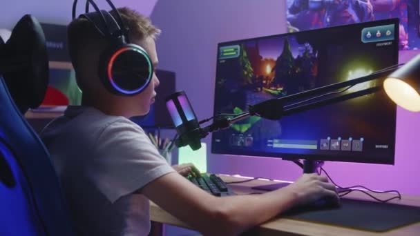 Νεαρός Gamer Ακουστικά Μιλάει Συμπαίκτες Και Παίζει Shooter Τρίτου Προσώπου — Αρχείο Βίντεο